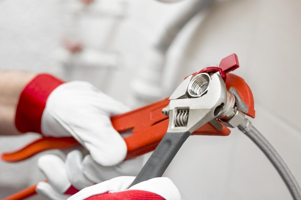 Plumber holding pipe wrenches for an emergency repair in Imperial Beach
