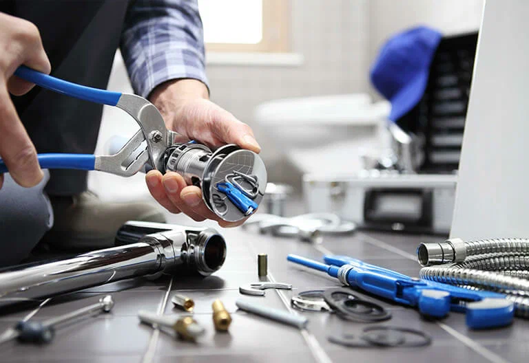 Technician repairing a plumbing fixture with professional tools in Imperial Beach
