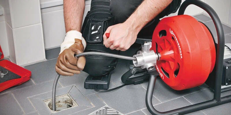 Plumber using a drain-cleaning machine in Imperial Beach