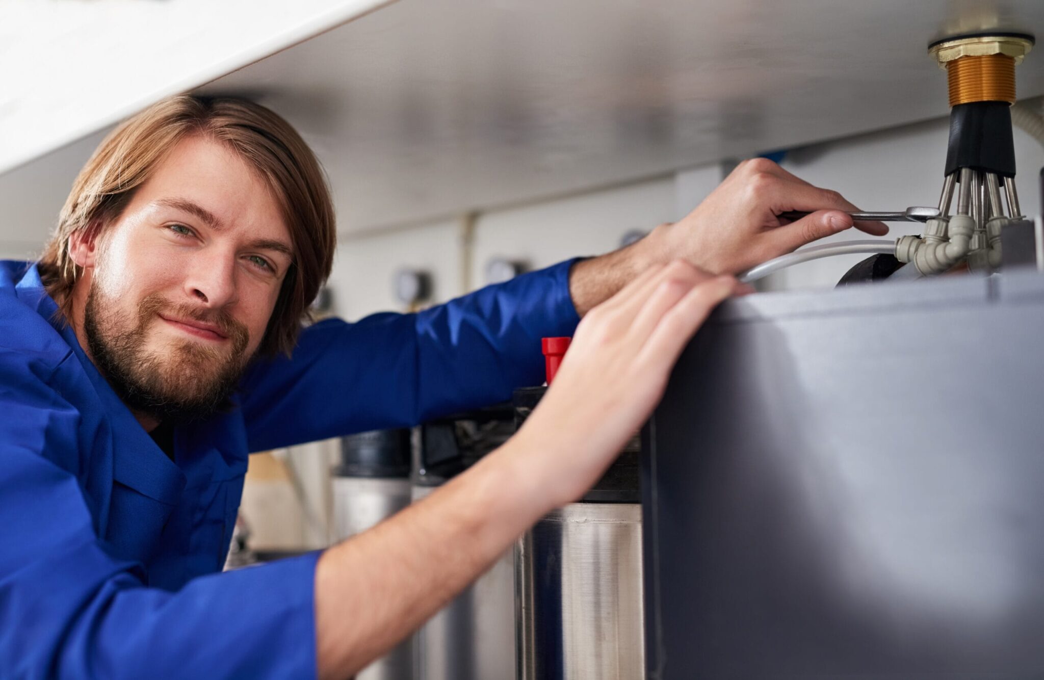 Technician servicing a residential water heater tank in Imperial Beach